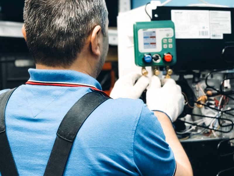 A technician's gauges connected to a refrigeration system
