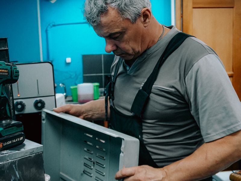 A repair technician examining a home appliance